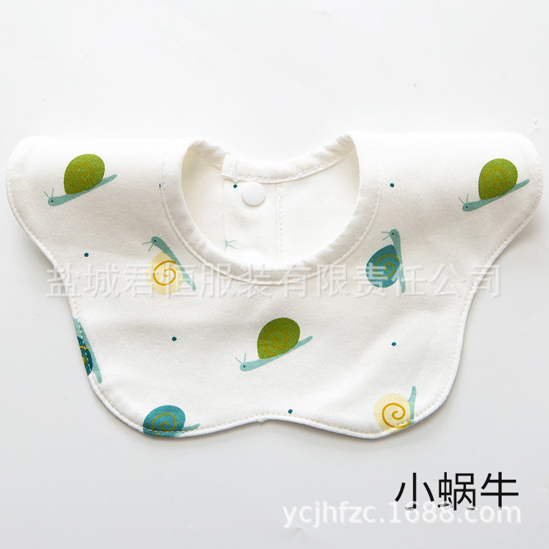 Baby bib with green and blue designs on a white background