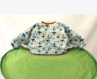 Baby bib with colorful patterns on a green chair