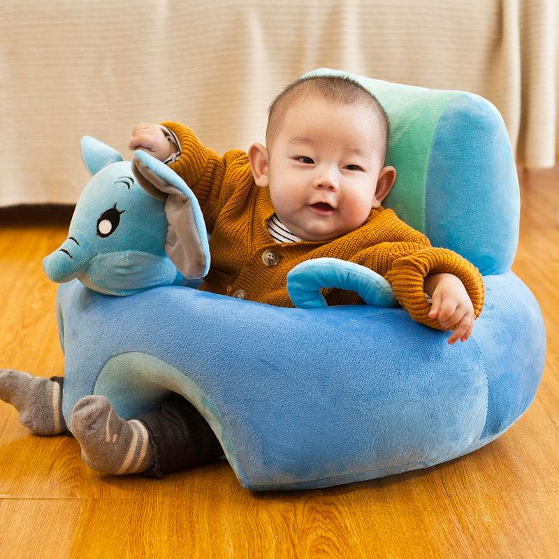 Child sitting in a blue plush chair with a toy on a wooden floor