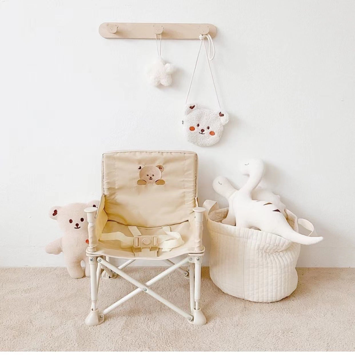 Children's chair with teddy bear design, plush toys, and a basket on a carpeted floor.