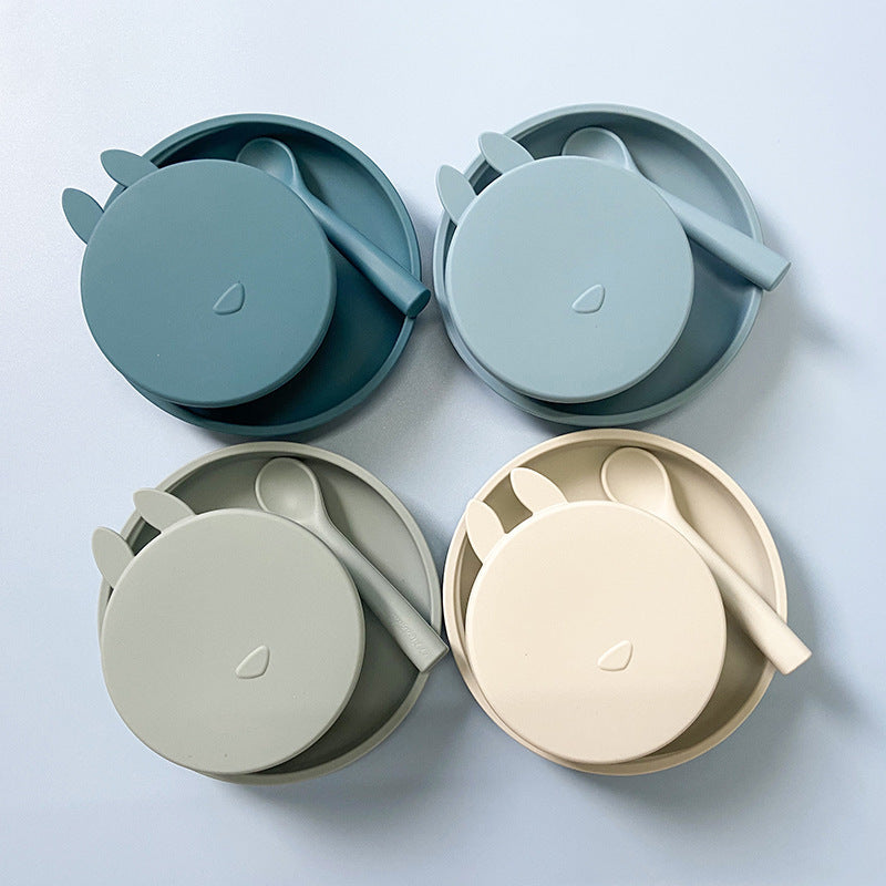 Set of four children's lunch boxes with lids in different colors on a light blue background