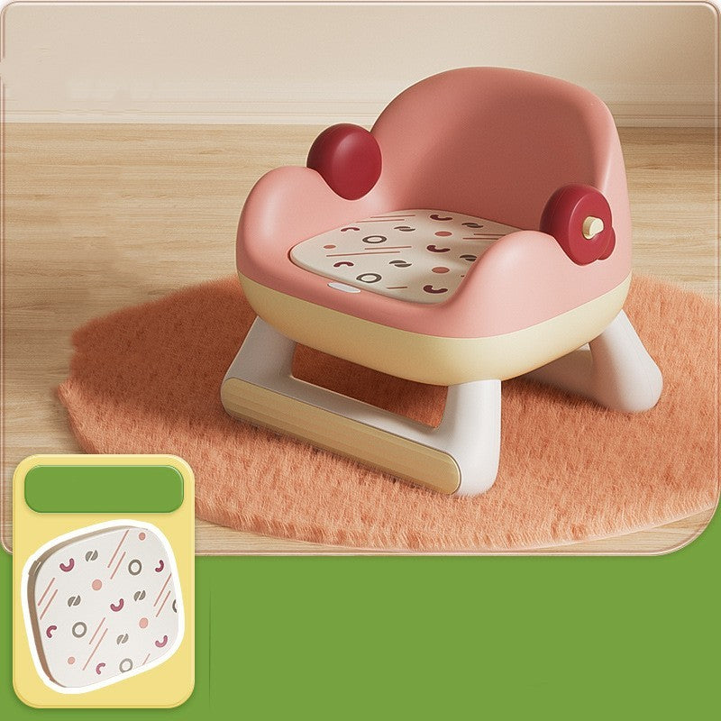 Children's training seat with a patterned cushion on a wooden floor.