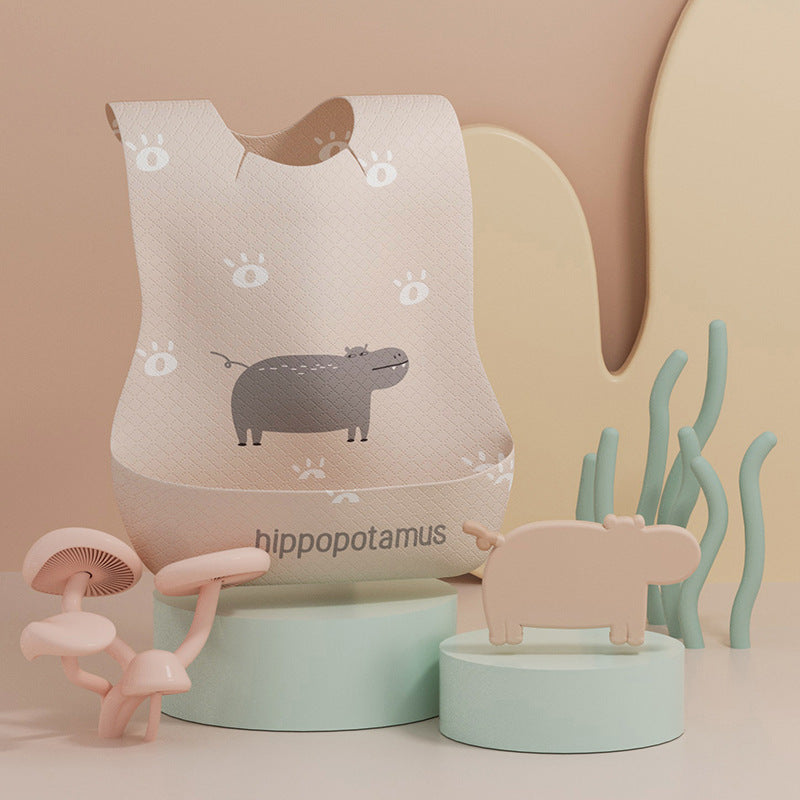 Baby bib with hippo design and related toys on a beige background