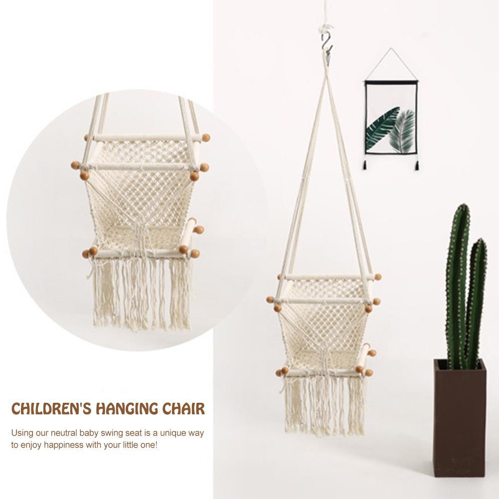 Children's hanging chair with neutral design, shown with a cactus plant on a white background.