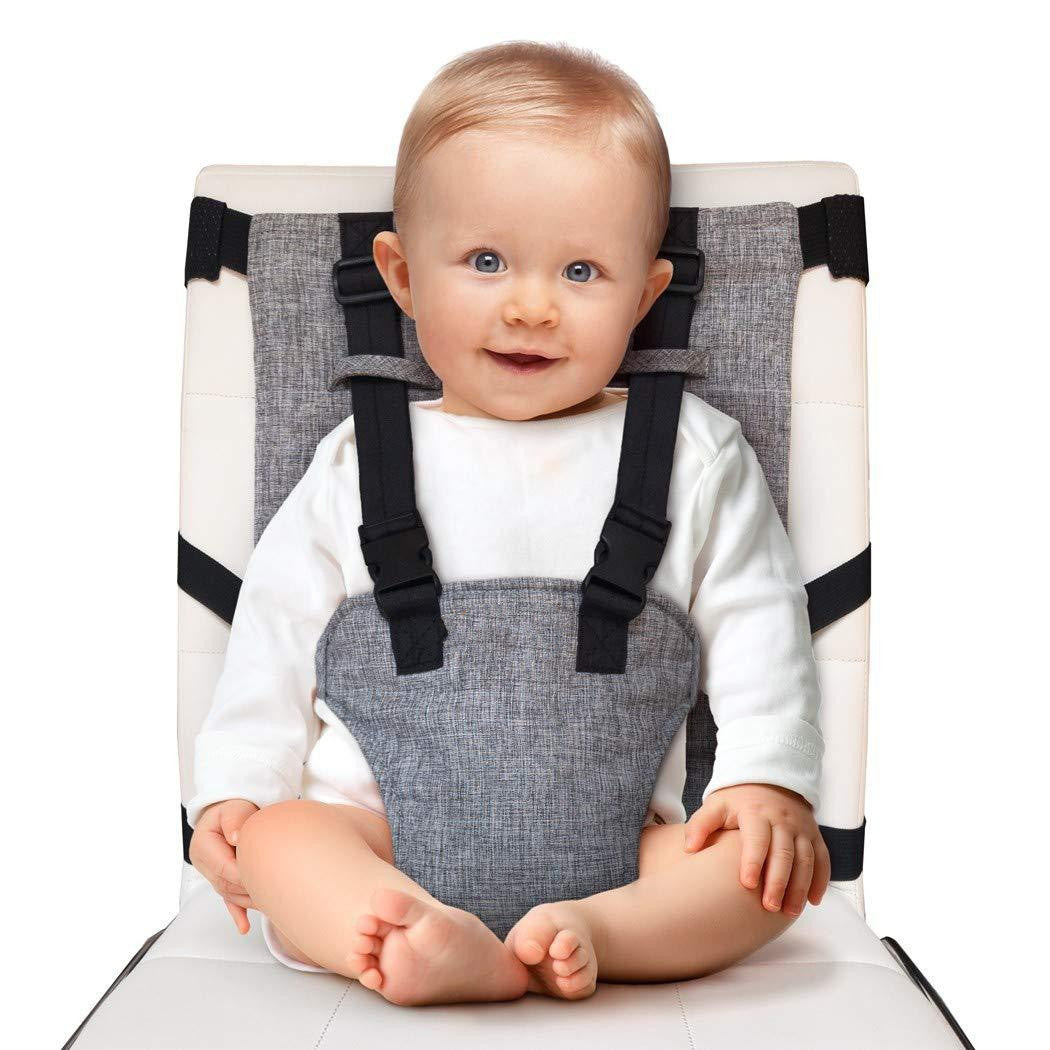 Baby sitting in a gray and black baby seat with a white background