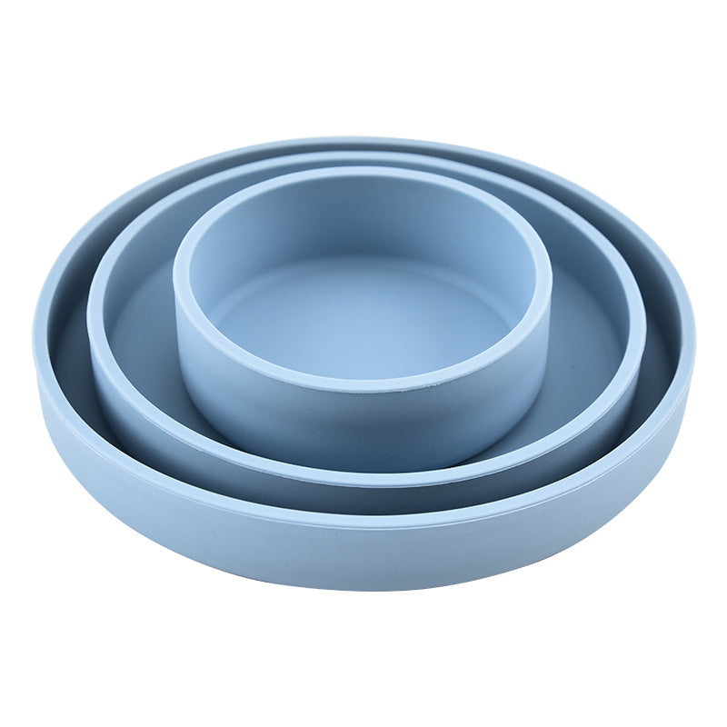 Set of three blue silicone bowls of different sizes on a white background