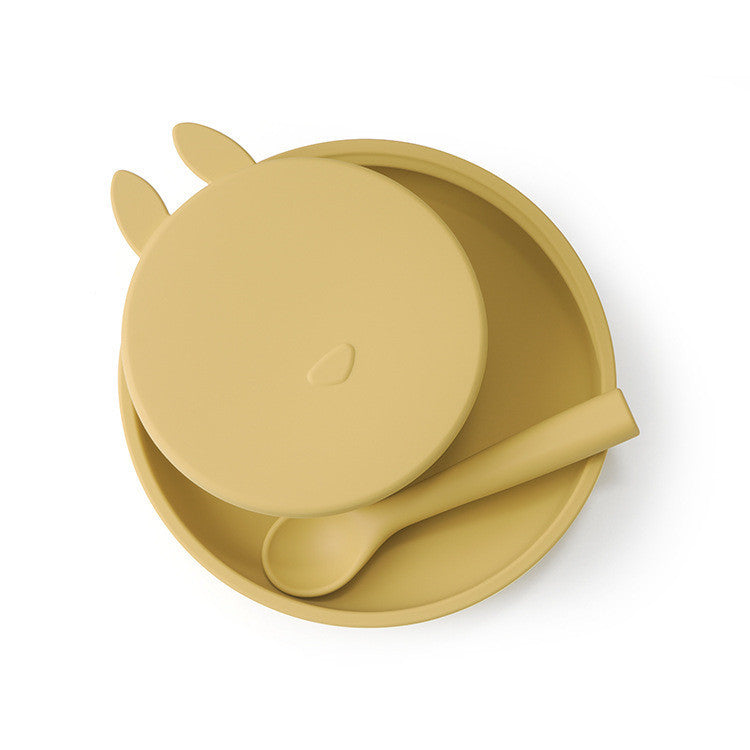 Yellow silicone bowl with lid and spoon on a white background