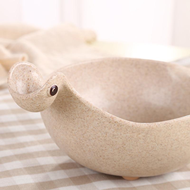 Beige ceramic bowl shaped like a duck on a checkered fabric background