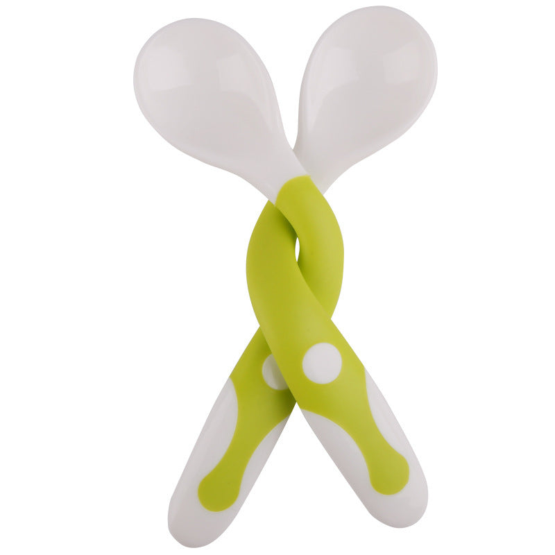 Pair of white spoons with green handles on a white background