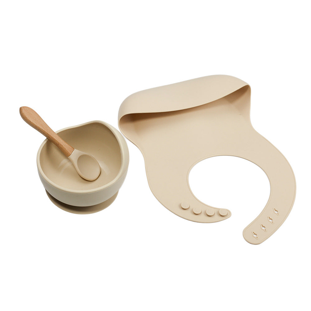 Beige bowl with spoon and bib on a white background