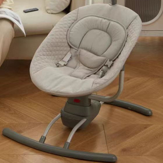 Gray baby swing on a wooden floor with a blurred background