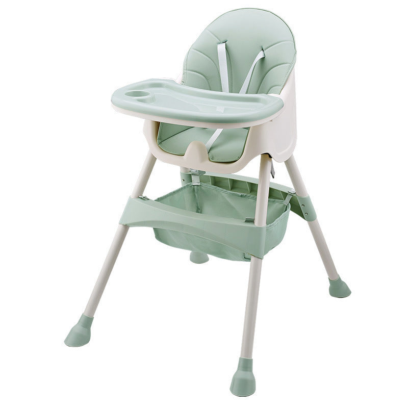 Green baby high chair with tray on a white background