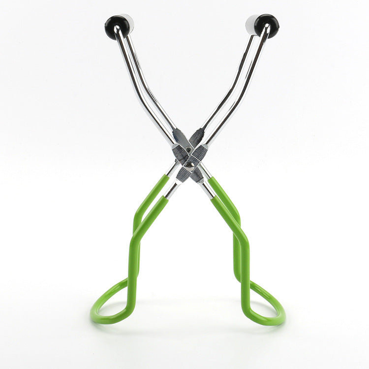 Green and silver eyelash curler on a white background