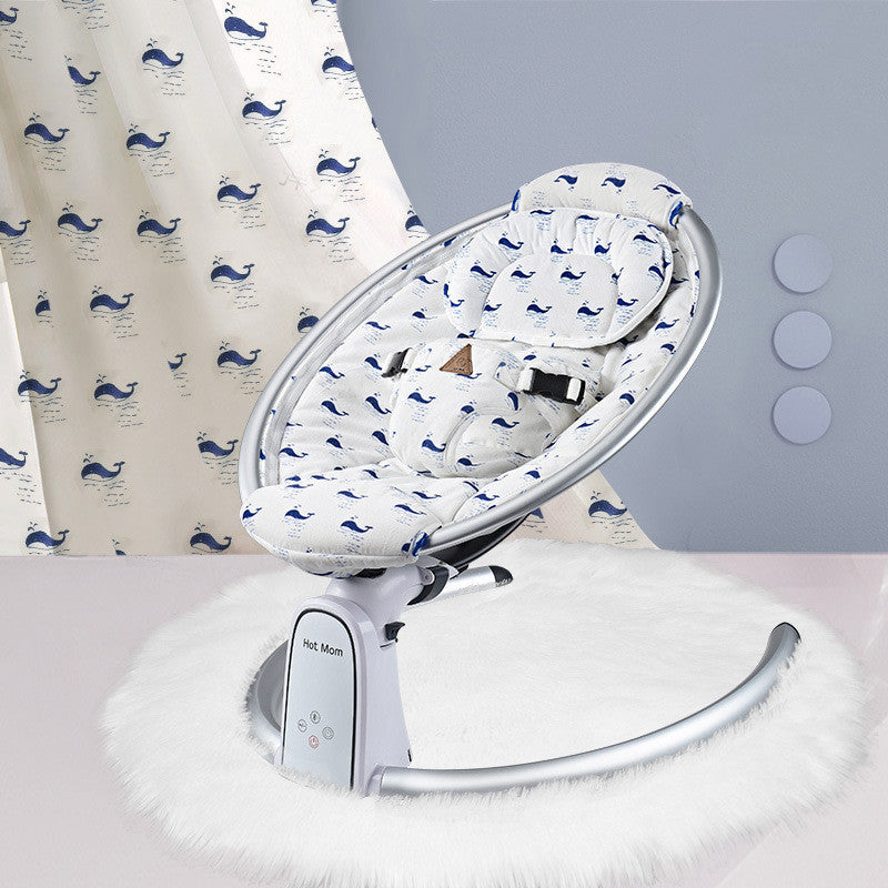 Baby swing with whale patterned cover against a light gray wall