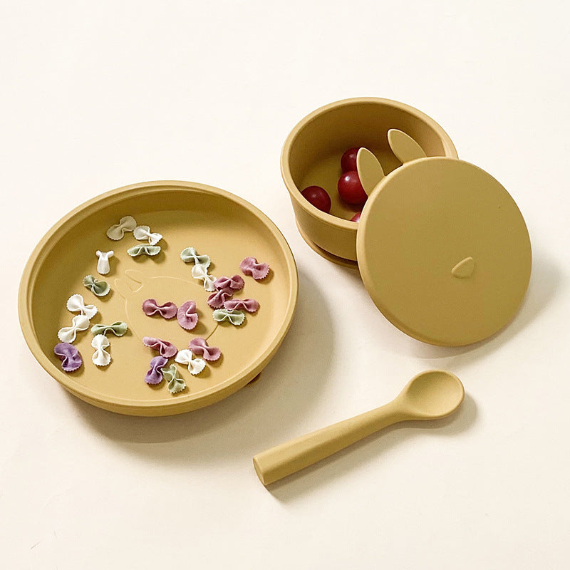 Yellow children's plate, bowl, and spoon set on a white background