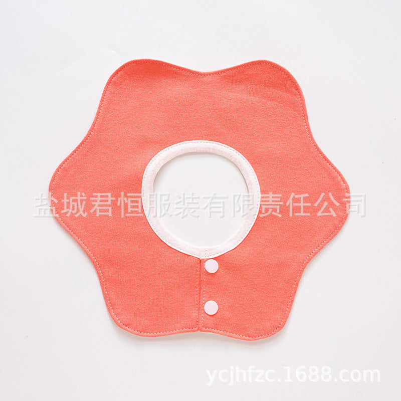 Pink baby bib with white buttons on a light gray background