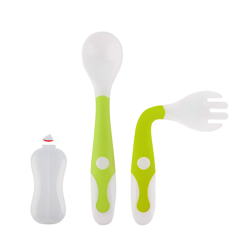 Set of green and white baby utensils including a spoon, fork, and bottle on a white background