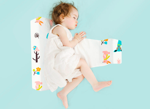 Triangular washable baby side sleeping pillow with colorful animal print by Nestacular