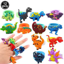 Set of colorful dinosaur-shaped rings on a hand with a hand holding one ring.