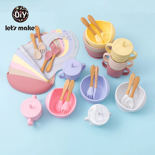 Set of colorful children's tableware including cups, bowls, and utensils on a light blue background.