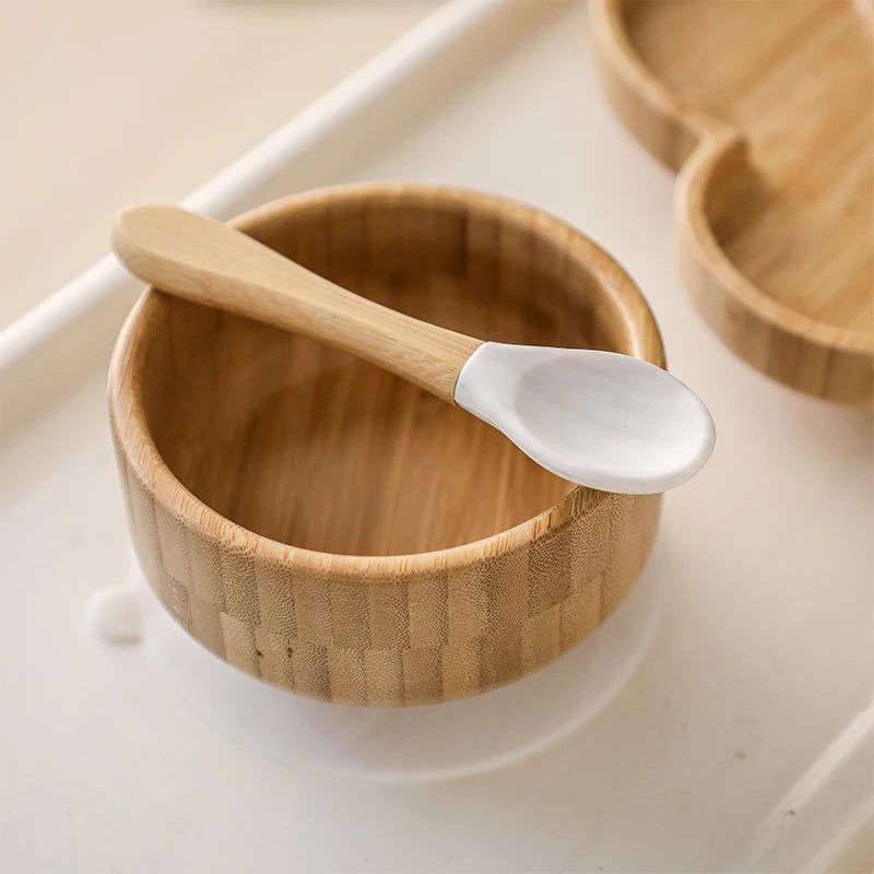 Wooden bowl with a white-handled wooden spoon on a light background