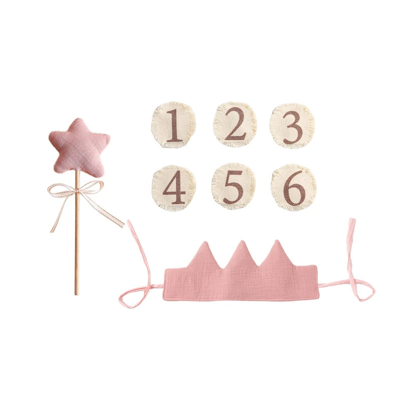 Pink star wand, pink crown, and wooden numbers on a white background