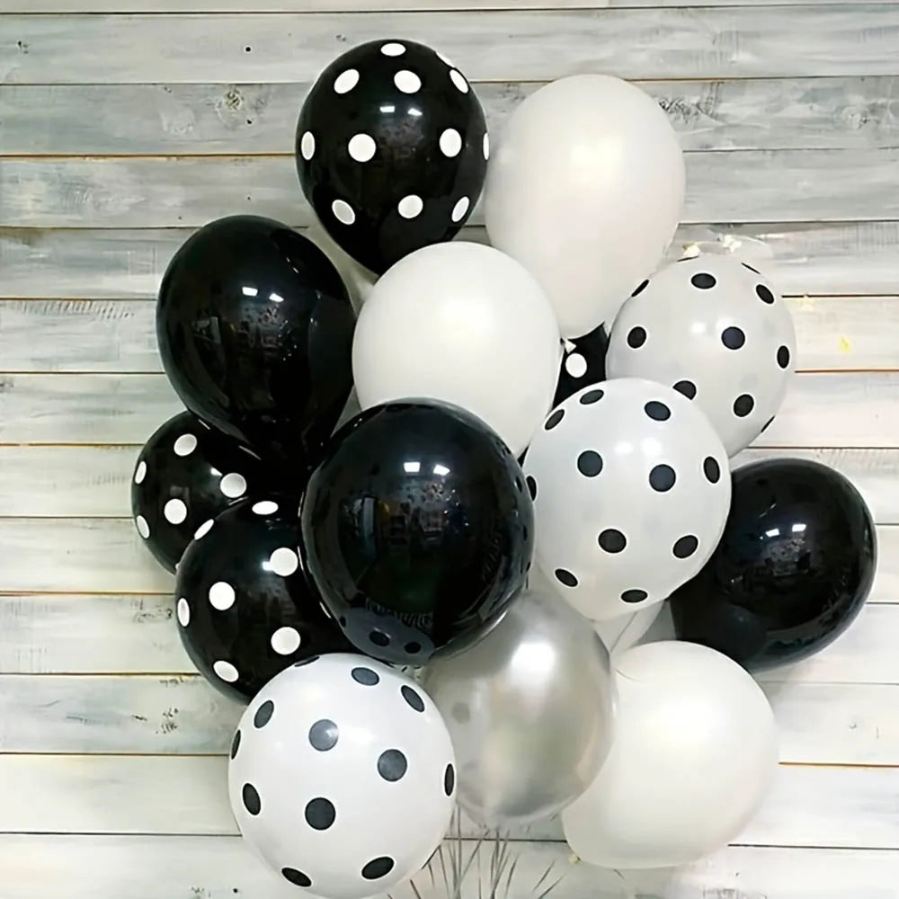 Balloons with black, white, and silver polka dots on a wooden background