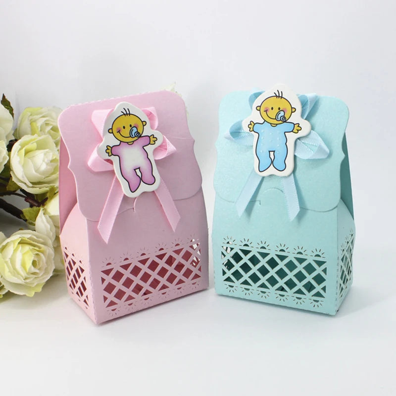 Pink and blue baby shower favor boxes with decorative ribbons and baby-themed tags on a white background.