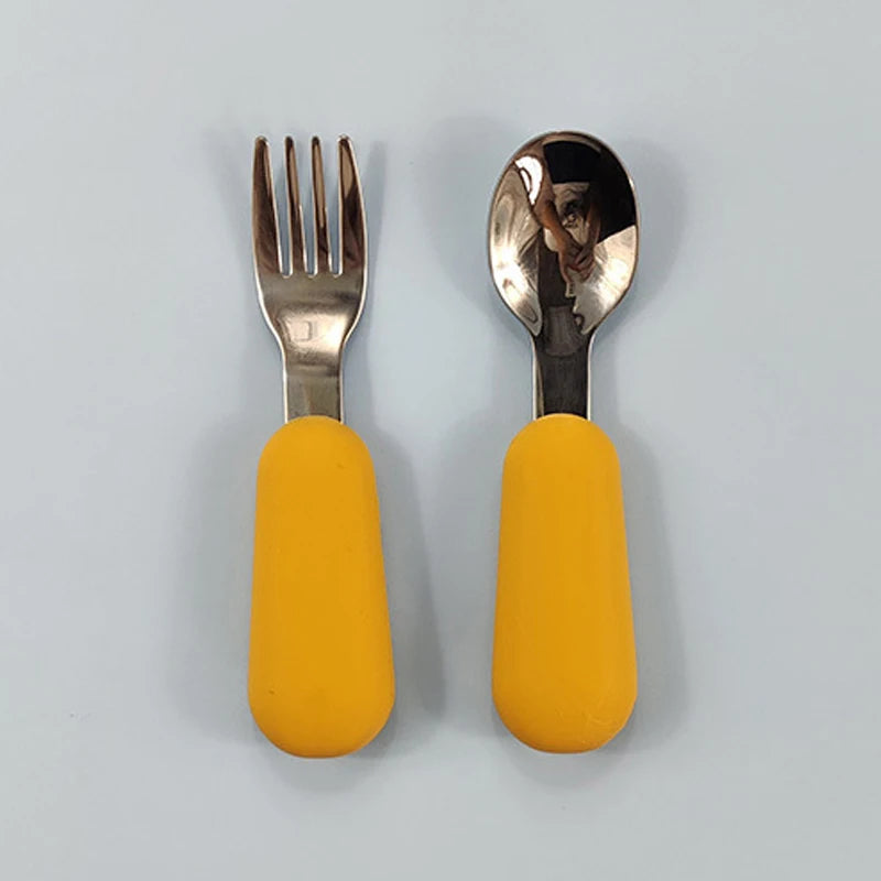 Fork and spoon set with yellow handles on a light gray background