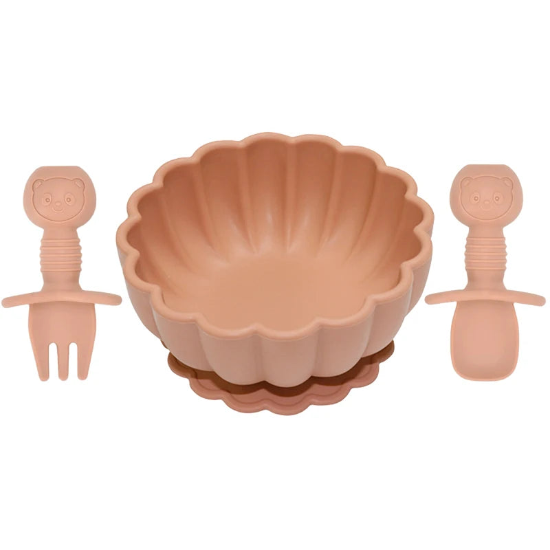 Set of pink children's bowl, fork, and spoon on a white background