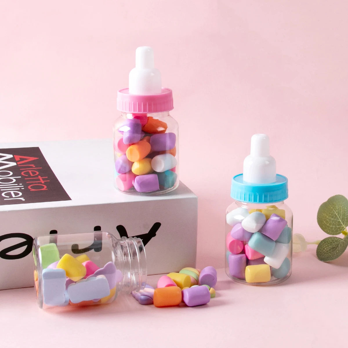 Bottles filled with colorful candies on a pink background