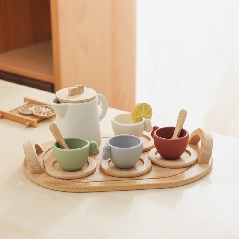 Set of ceramic cups and a teapot on a wooden tray with a light background
