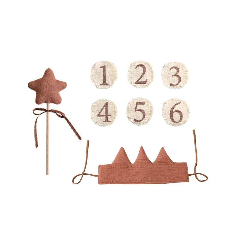 Children's birthday party decorations including a star-shaped cake topper, number cards, and a crown on a white background.