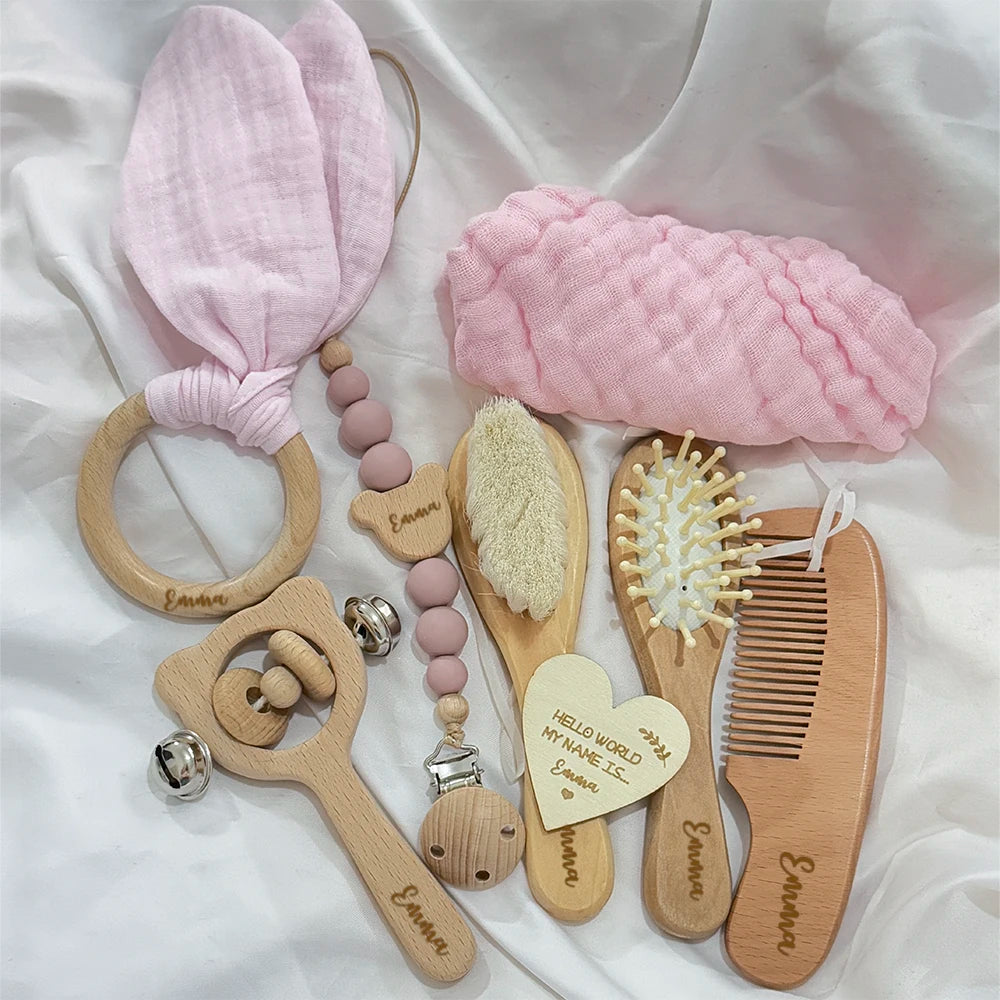 Collection of baby care items including a teething ring, rattle, and brushes on a white background.