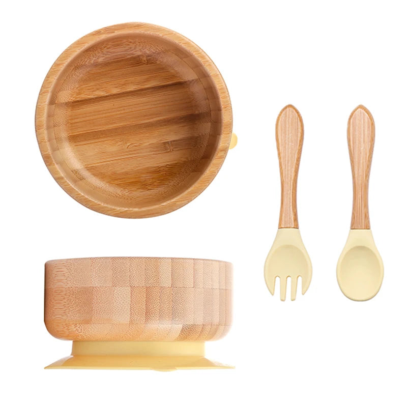 Wooden bowl set with yellow base and matching fork and spoon on a white background