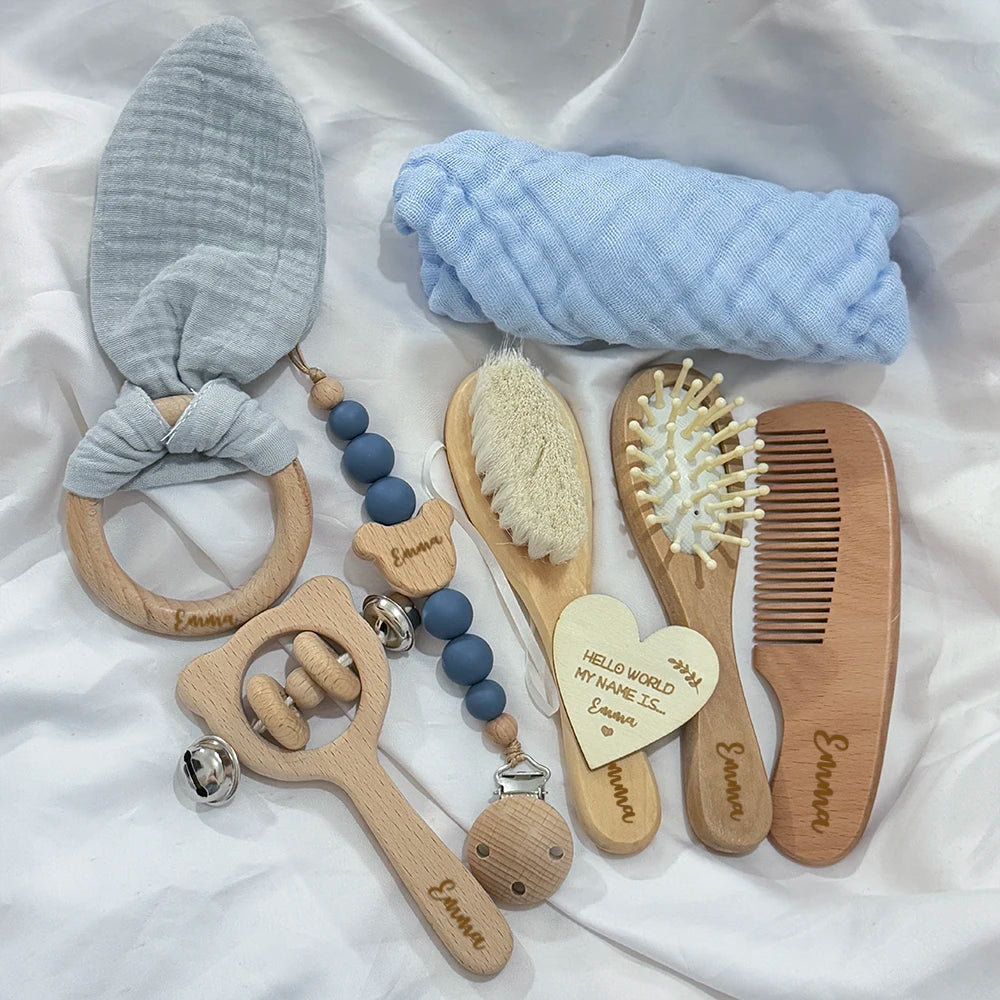 Collection of baby care items including a teething ring, rattle, and grooming tools on a white background.