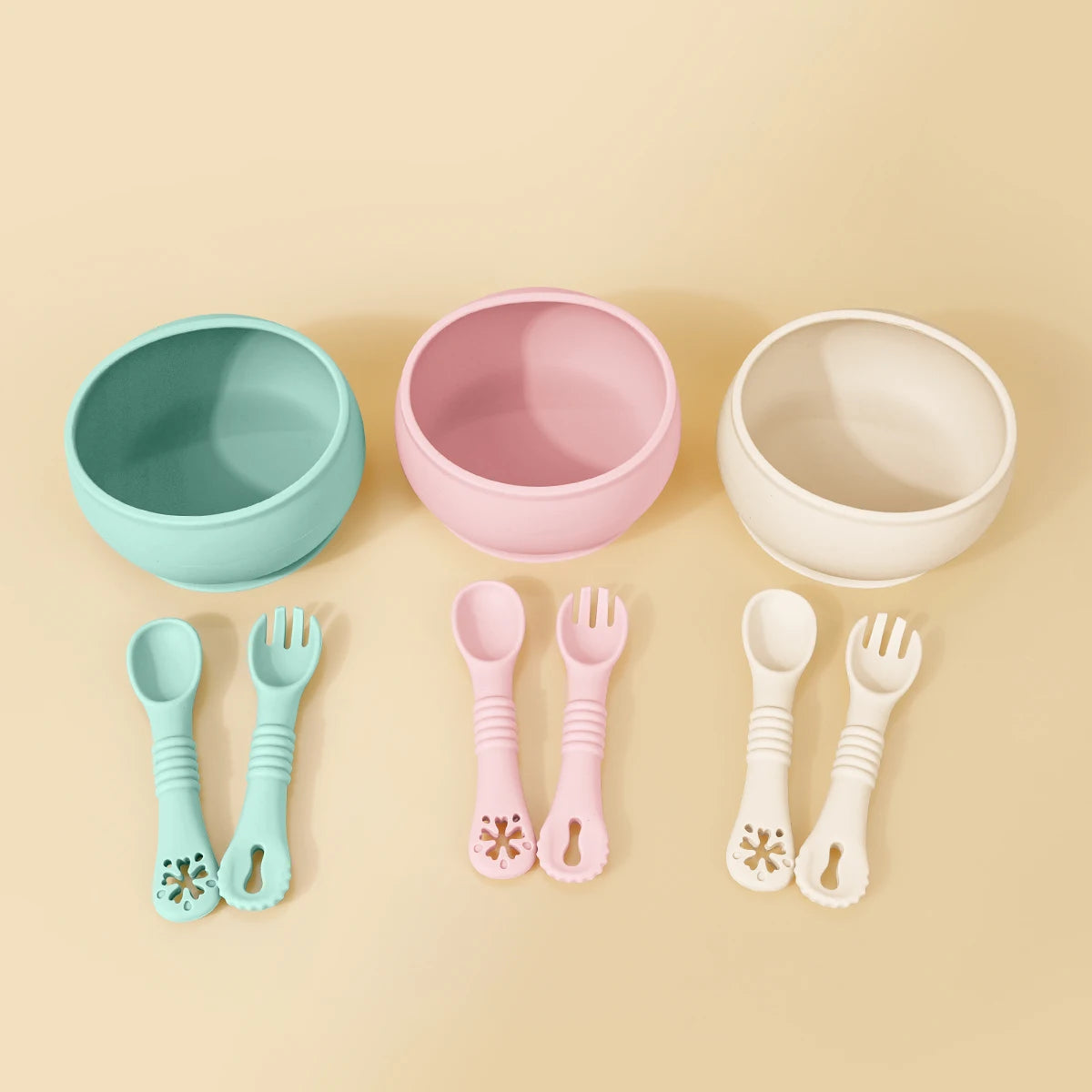 Set of colorful bowls and utensils on a beige background