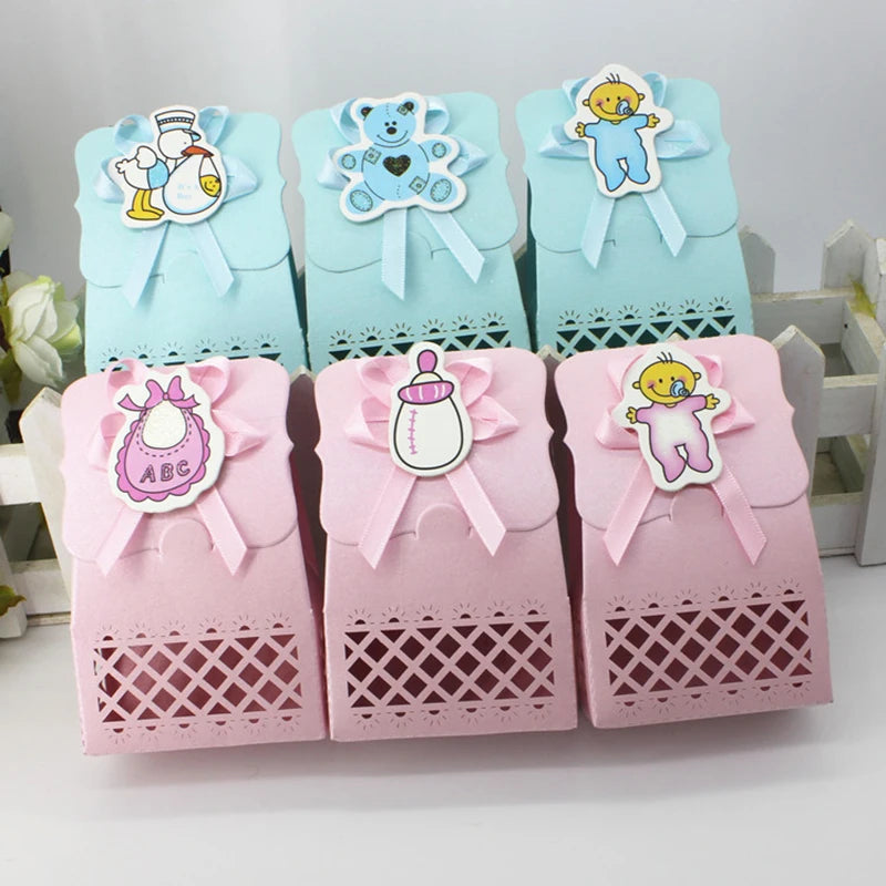 Set of baby-themed gift boxes in blue and pink with decorative elements on a white background.