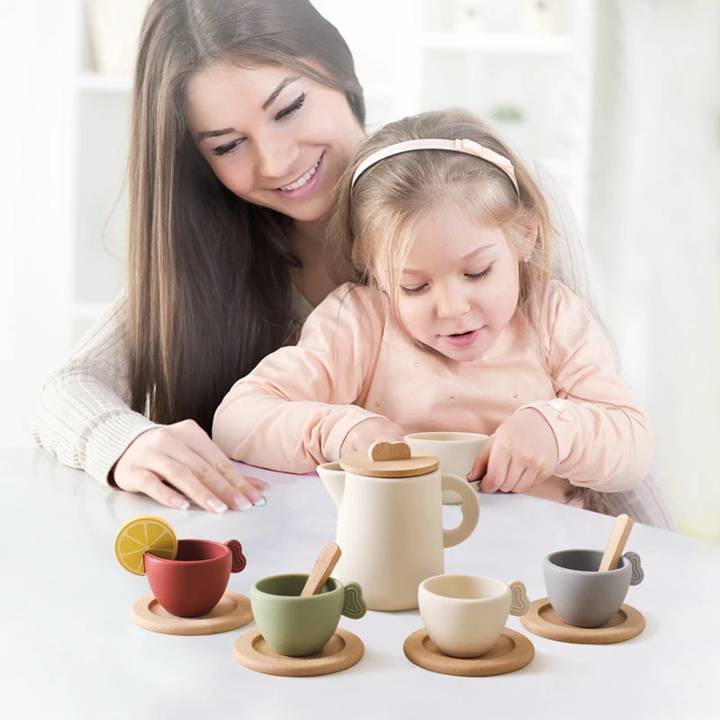 Woman and child playing with ceramic tea set on a white table