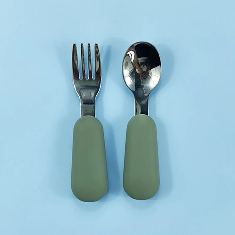 Spoon and fork set with green handles on a light blue background