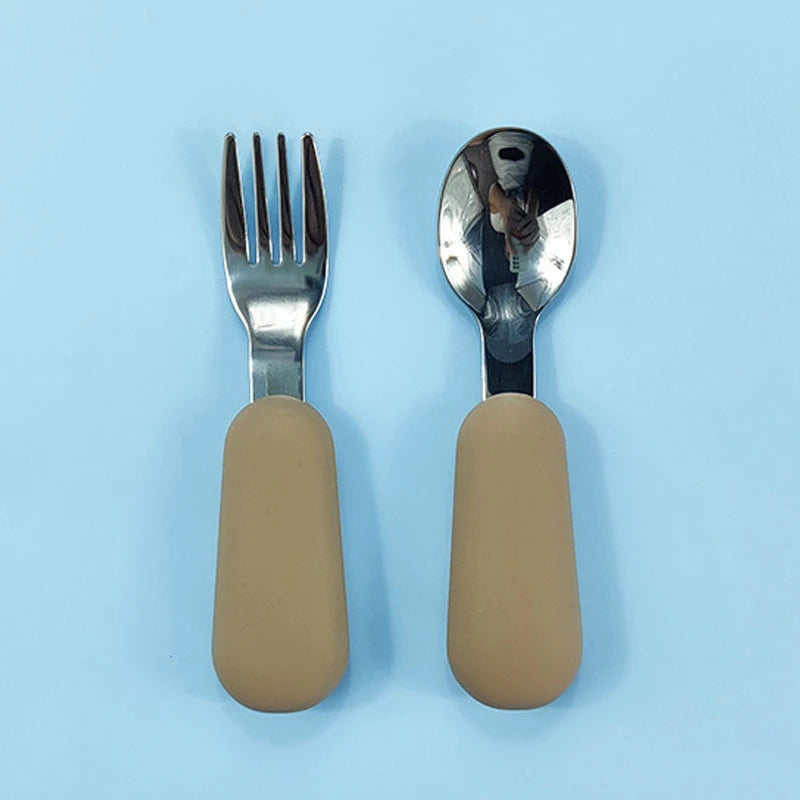 Fork and spoon set with beige handles on a light blue background