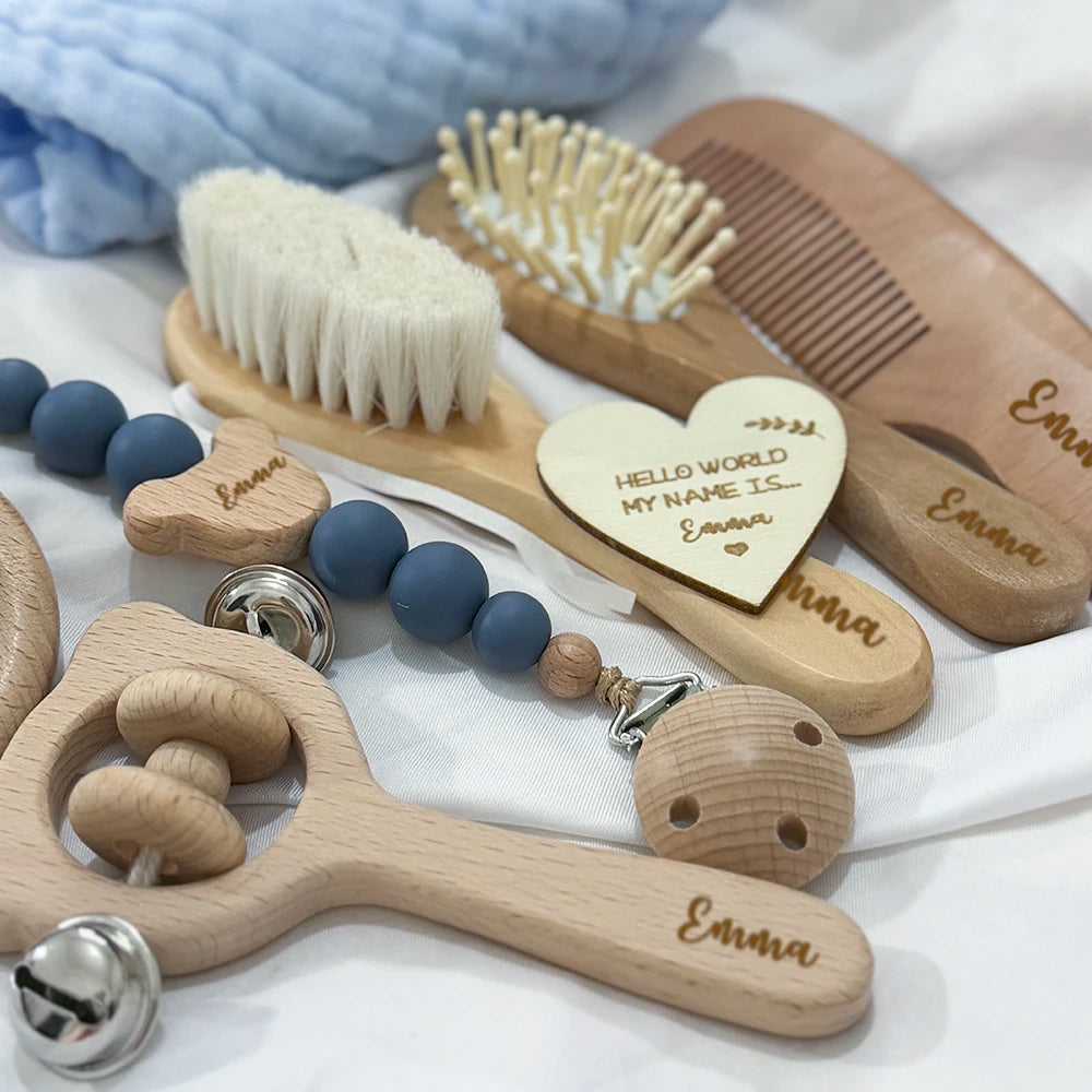 Collection of wooden baby toys with engraved names on a white background