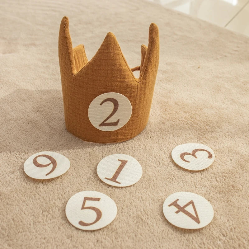 Wooden crown with number '2' on a beige surface