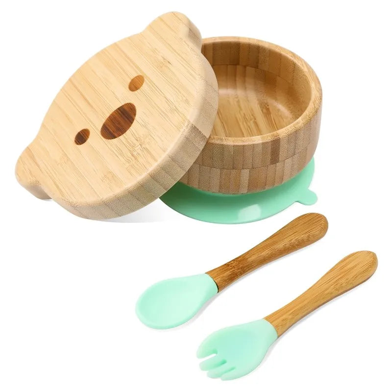 Bamboo baby bowl with lid, spoon, and fork set on a white background