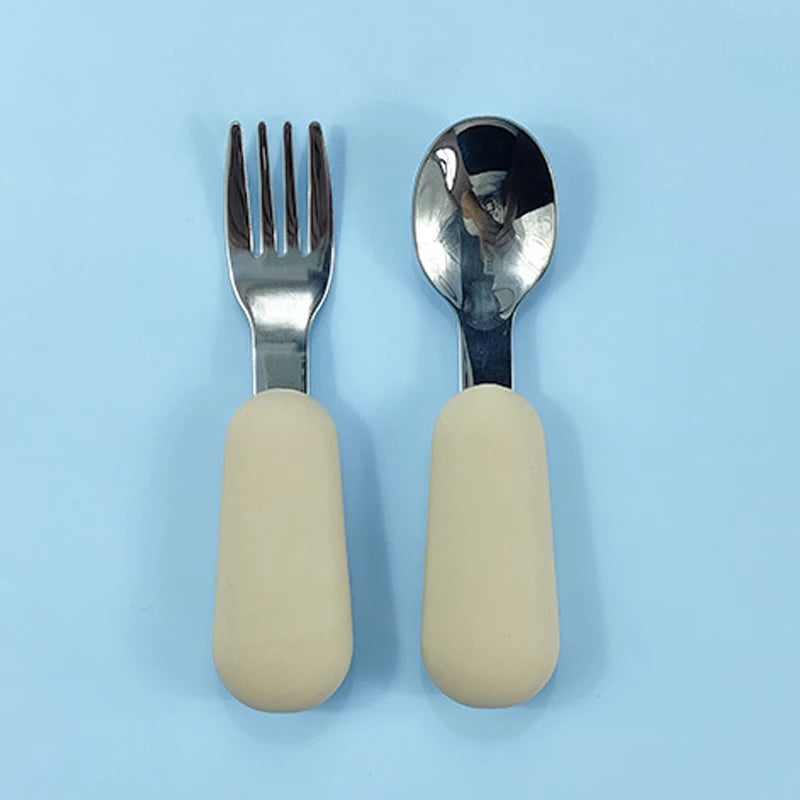 Stainless steel fork and spoon with beige handles on a light blue background