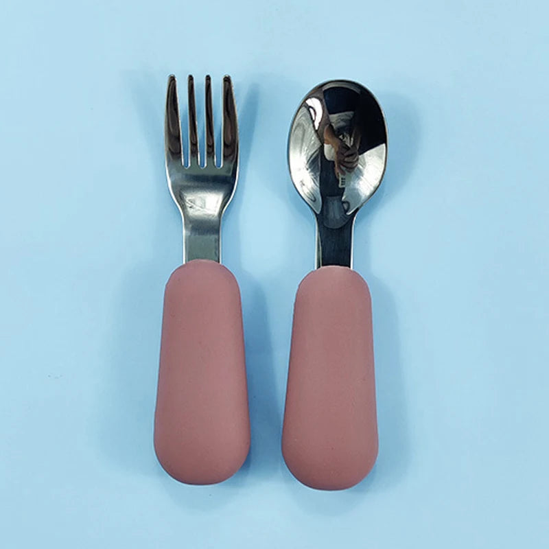 Fork and spoon set with pink handles on a light blue background