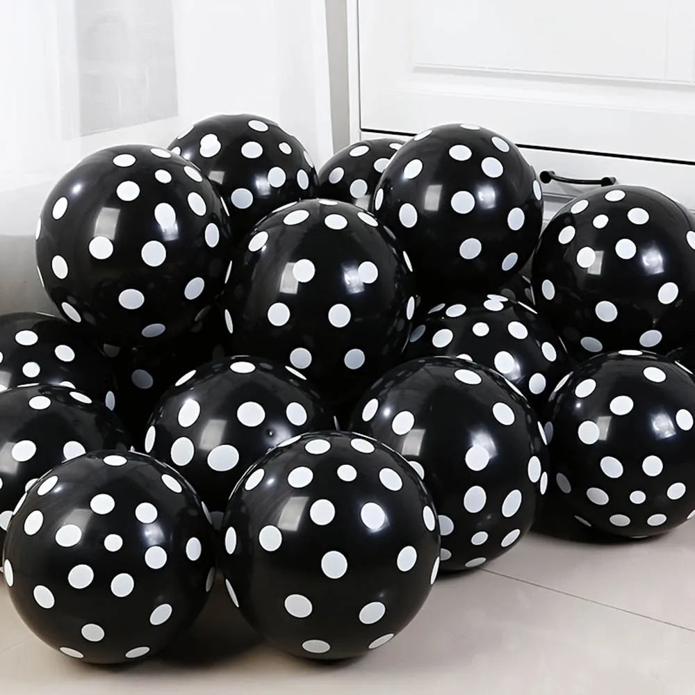 Black balloons with white polka dots on a light-colored floor.