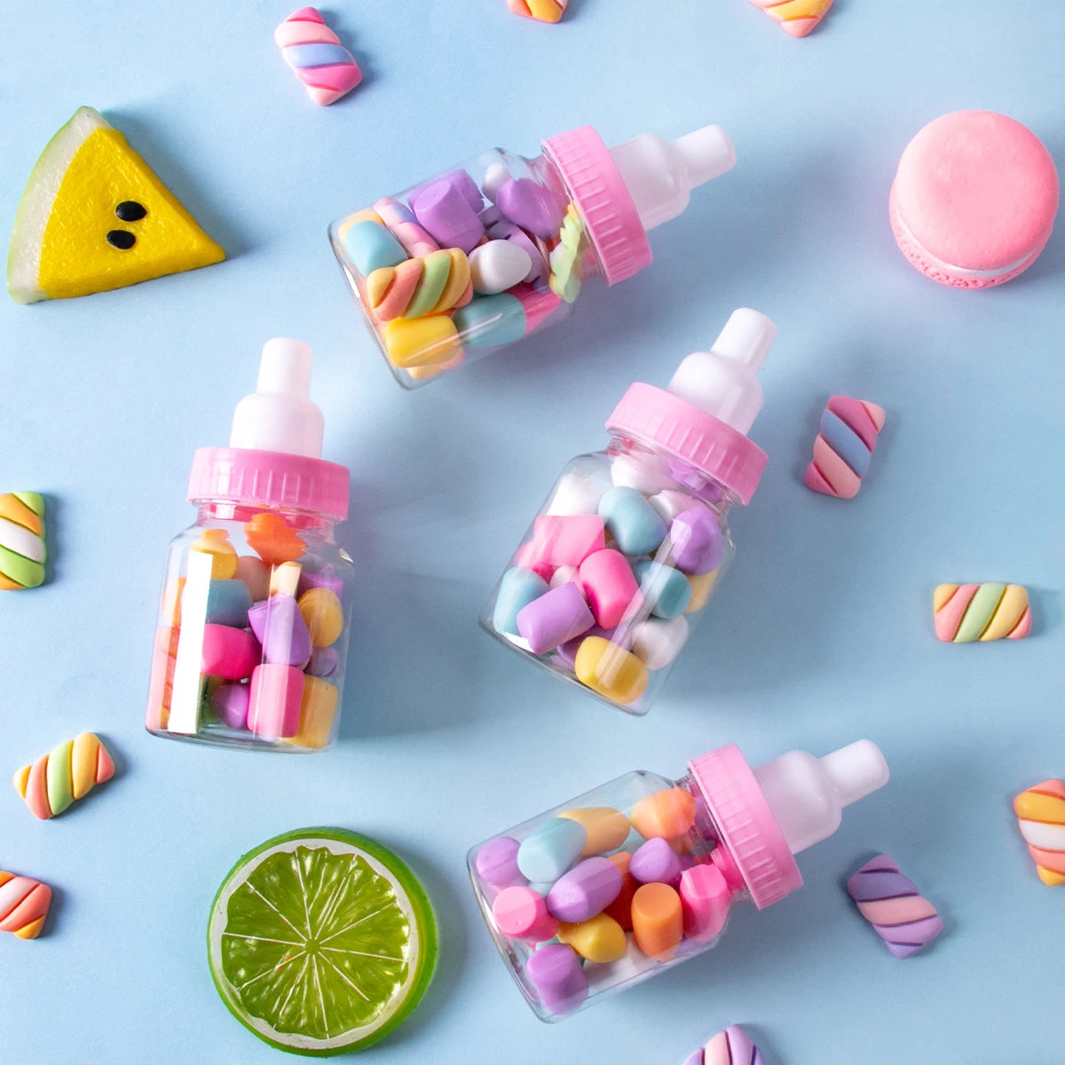 Small glass bottles filled with colorful candies on a blue background with candy decorations.