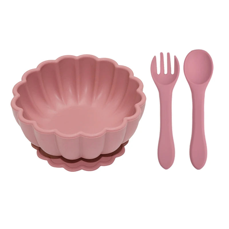 Pink children's bowl, fork, and spoon set on a white background