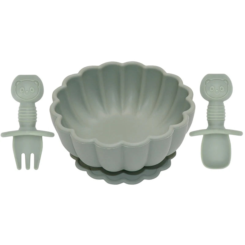 Set of green silicone utensils and a mold on a white background